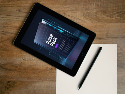 A tablet device lying on a wooden surface, angled diagonally, with a blank sheet of paper and a stylus beside it. The tablet screen displays a digital cover titled 'Pulse Pack'.